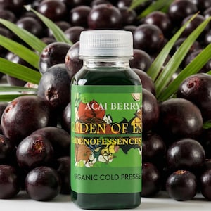 May include: A clear bottle of green liquid with a white cap, labeled "Acai Berry Garden of Essences Organic Cold Pressed." The bottle is surrounded by dark purple acai berries and green leaves.