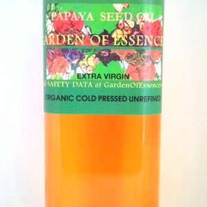 K&ouml;nnte beinhalten: Eine durchsichtige Kunststoffflasche gef&uuml;llt mit orangefarbenem Papayasamen&ouml;l. Das gr&uuml;ne Etikett tr&auml;gt den Text PAPAYA SEED OIL, GARDEN OF ESSENCE, EXTRA VIRGIN und ORGANIC COLD PRESSED UNREFINED sowie ein buntes florales Grafikdesign.