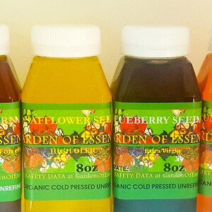 May include: Four bottles of Garden of Essences oils, each with a white cap and a green label. The bottles contain oils of varying colors: dark red, yellow, dark purple, and orange. Each bottle is 8 oz.