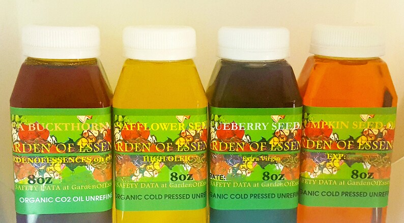 May include: Four bottles of Garden of Essences oils, each with a white cap and a green label. The bottles contain oils of varying colors: dark red, yellow, dark purple, and orange. Each bottle is 8 oz.