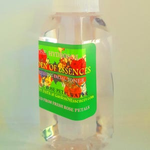 K&ouml;nnte beinhalten: Eine klare Glasflasche mit wei&szlig;em Verschluss, gef&uuml;llt mit einer hellrosa Fl&uuml;ssigkeit. Das Etikett ist gr&uuml;n mit wei&szlig;em Text, der "Rose Hydrosol Garden of Essences Refreshing Facial Toner Organic Rose Petal Water My Data at GardenOfEssences.com Distilled from Fresh Rose Petals" lautet.