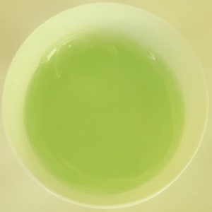 May include: A white ceramic bowl filled with a light green liquid.