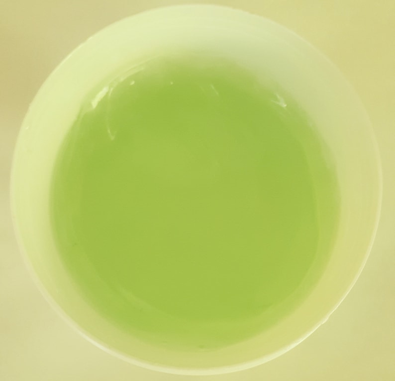 May include: A white ceramic bowl filled with a light green liquid.