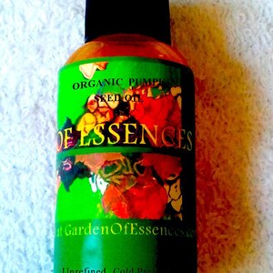 Puede incluir: Una botella de aceite de semilla de calabaza org&aacute;nico con tapa negra. La etiqueta verde tiene las palabras "Organic Pumpkin Seed Oil" y "Garden Of Essences". La parte inferior de la etiqueta dice "Unrefined Cold Pressed".