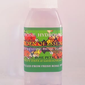 K&ouml;nnte beinhalten: Eine durchsichtige Plastikflasche mit wei&szlig;em Deckel, gef&uuml;llt mit einer hellrosa Fl&uuml;ssigkeit. Das Etikett ist gr&uuml;n mit einem floralen Design und dem Text "ROSE HYDROSOL GARDEN OF ESSENCE REFRESHING FACIAL TONE ORGANIC ROSE PETAL WATER SAFETY DATA at GardenOfEssence FILLED FROM FRESH ROSE PETALS".