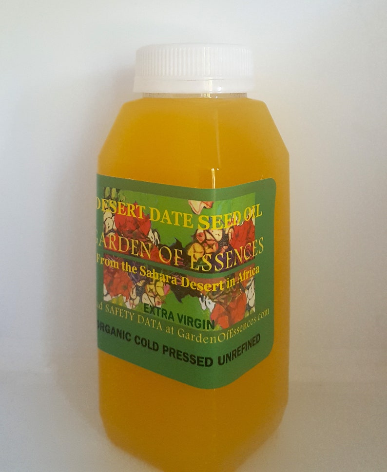 May include: A clear plastic bottle filled with a yellow liquid, labelled "Desert Date Seed Oil, Garden of Essences, From the Sahara Desert in Africa, Extra Virgin, Organic Cold Pressed Unrefined".