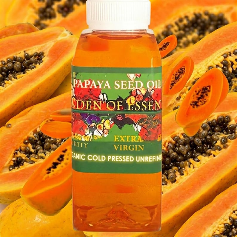 K&ouml;nnte beinhalten: Eine durchsichtige Kunststoffflasche gef&uuml;llt mit bernsteinfarbenem Papayasamen&ouml;l, mit wei&szlig;em Verschluss und einem gr&uuml;nen Etikett mit dem Text PAPAYA SEED OIL, EDEN OF ESSENCE, EXTRA VIRGIN, ORGANIC COLD PRESSED UNREFINED, vor einem Papaya-Hintergrund.