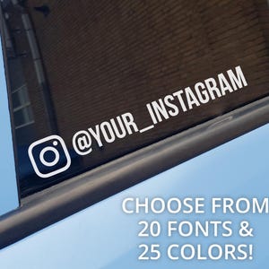 May include: A white vinyl decal applied to a dark window surface, featuring the Instagram camera icon followed by the text @YOUR_INSTAGRAM in a sans-serif font. The image includes overlay text stating CHOOSE FROM 20 FONTS & 25 COLORS!