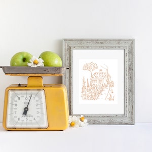 May include: A yellow vintage kitchen scale with two green apples and a white daisy on top. A framed print of a line drawing of a house in a garden is on the right side of the image.