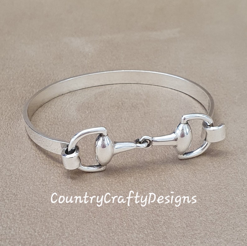 K&ouml;nnte beinhalten: Silbernes Armreif-Armband mit einem Pferdebiss-Design. Das Armband ist schlicht und elegant, perfekt f&uuml;r den Alltag.