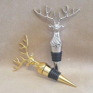 May include: Two decorative bottle stoppers shaped like deer heads. One is silver and the other is gold.