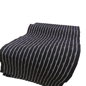 May include: Black and white striped fabric with a subtle woven pattern. The fabric is folded and draped on a white background.