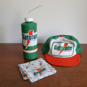 May include: A green Gatorade water bottle with a white straw, a Gatorade trucker hat with a green mesh back and orange brim, and a Gatorade bandana. All items feature the Gatorade logo with a lightning bolt.