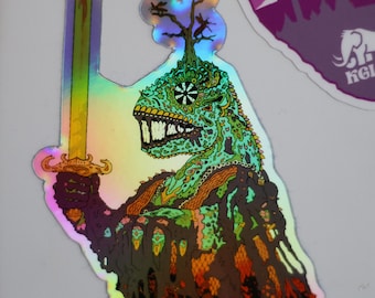 May include: Holographic sticker featuring a lizard-like creature holding a sword. The creature is green and brown with a tree growing from its head. The sticker has a rainbow sheen and is affixed to a white surface. Other stickers are visible.
