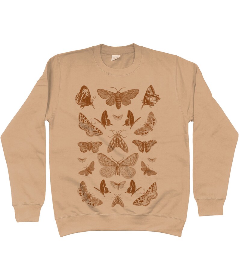 May include: A beige sweatshirt with a pattern of brown butterflies and moths. The design features a variety of butterfly and moth species, including some with intricate wing patterns.