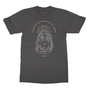 May include: A dark gray t-shirt with a white outline of a woman with celestial tattoos and the text "I spoke to you Aphrodite, in a dream" in gold lettering. The text "Sappho" is also in gold lettering at the bottom of the design.