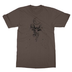 May include: A brown t-shirt with a black graphic of a fairy flying with wings outstretched under a crescent moon with stars.