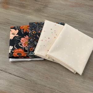 May include: Four folded fabric squares with floral and star patterns. The fabrics feature a variety of colors, including black, orange, cream, and navy. The floral patterns include large blooms and smaller, detailed designs.