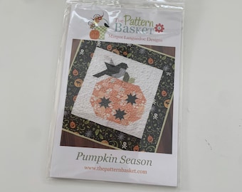 May include: A quilting pattern for a pumpkin with a bird on top. The pattern is called "Pumpkin Season" and is from The Pattern Basket by Margot Languedoc Designs. The pattern is printed on white paper with a black border.