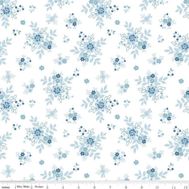 Peut inclure: Tissu blanc avec un motif r&eacute;p&eacute;titif de bouquets floraux bleus. Les bouquets sont compos&eacute;s de petites fleurs bleues et de feuilles.