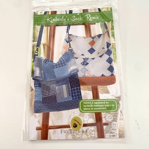 May include: A clear plastic package containing a sewing pattern for a patchwork bag. The pattern is titled "Kimberly's Sack: Remix" and features images of the finished bags in blue and white fabrics. The Fig Tree & Co. logo is visible.