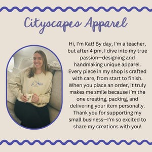 May include: A woman smiles while holding a mug in a light beige sweatshirt with a mountain graphic. The text "Cityscapes Apparel" is at the top of the image. The text below the image reads "Hi, I'm Kat! By day, I'm a teacher, but after 4 pm, I dive into my true passion-designing and handmaking unique apparel. Every piece in my shop is crafted with care, from start to finish. When you place an order, it truly makes me smile because I'm the one creating, packing, and delivering your item personally. Thank you for supporting my small business-I'm so excited to share my creations with you!"