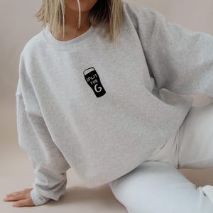 May include: A gray sweatshirt with a black graphic of a pint glass with the text "Split the G" on it.