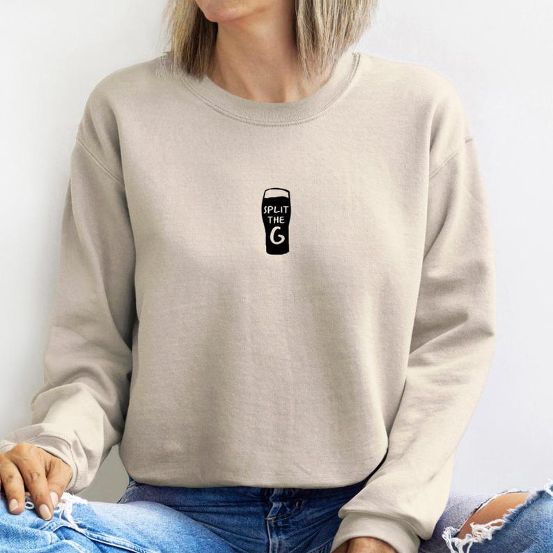 May include: A beige sweatshirt with a black graphic of a pint glass with the text "SPLIT THE G" printed on it.