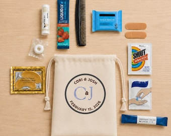 May include: A beige drawstring pouch printed with Cori & Josh, C&J, and February 15, 2026, surrounded by a lip balm, Liquid I.V. packet, black comb, makeup remover wipes, two bandages, Shout Wipe & Go, hand sanitiser, and gold eye masks.