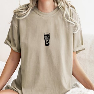 May include: A light beige t-shirt with a black graphic of a pint glass and the text "Split the G".