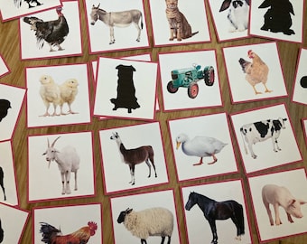 May include: A set of 16 matching cards featuring farm animals and their silhouettes. The cards are printed on white paper with a red border and feature images of a turkey, donkey, cat, rabbit, chicks, dog, tractor, chicken, goat, llama, duck, cow, rooster, sheep, horse, and pig.