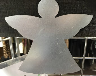 May include: A silver metal angel ornament with a loop for hanging. The ornament is a simple silhouette of an angel with wings and a halo.