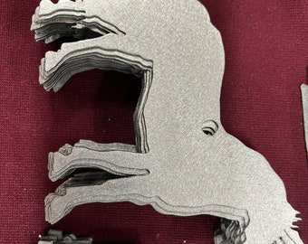 May include: A stack of metal cutouts in the shape of a horse, with the horse's head tilted down and its legs outstretched. The cutouts are a silver color and have a textured surface.