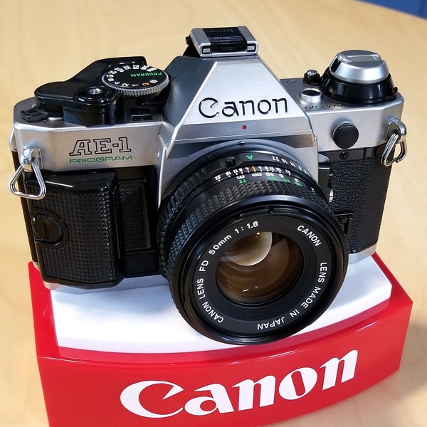 Klassische Canon AE-1 Programm 35-mm-Spiegelreflexkamera mit Canon NFD 50 mm f1.8-Objektiv, Kappen, Blitz – super sauber und filmgetestet – Anleitung – neuwertig