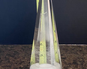 May include: A clear glass pyramid with a frosted white base. The pyramid is approximately 9 inches tall.