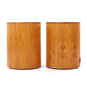 May include: Two wooden cylindrical side tables with a natural wood grain finish.