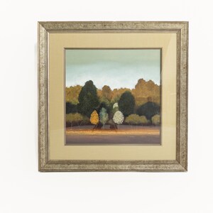 May include: A framed painting of a landscape with trees in shades of green, yellow, and brown. The trees are in the foreground of the painting, with a blue sky and clouds in the background.