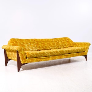 May include: A yellow velvet sofa with a geometric pattern. The sofa has a mid-century modern design with wooden legs.