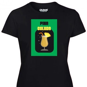 May include: Black t-shirt with a green rectangle featuring a cartoon illustration of a Pina Colada drink with a pineapple garnish and the text "Pina Colada".