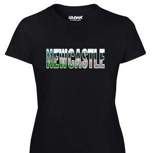 Może przedstawiać: Czarny T-shirt z białym obrysem słowa "NEWCASTLE" w zielono-niebiesko-białej kolorystyce. Słowo składa się z serii obraz&oacute;w stadionu.