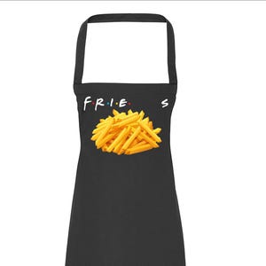 May include: Black apron featuring the word "FRIES" in a colorful font, with a pile of golden french fries. The apron has a neck loop and waist ties.
