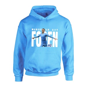 May include: A light blue hoodie with a white graphic of a soccer player with the text "MANCHESTER CITY" and "FODEN #47".