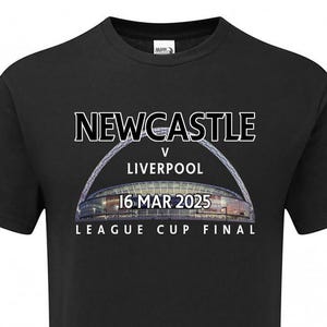 May include: Black t-shirt with white text that reads "NEWCASTLE v LIVERPOOL 16 MAR 2025 LEAGUE CUP FINAL". The text is over a photo of a stadium.