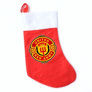 May include: Red and white Christmas stocking featuring the Manchester United logo, with the words "United", "Red", and "Army" around a crest with a trident and footballs.