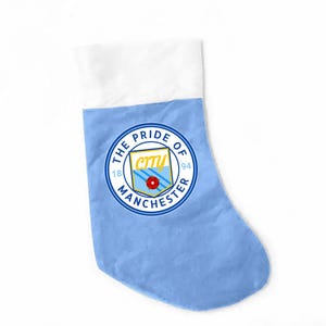 May include: A light blue Christmas stocking with a white cuff. The stocking displays a circular emblem with the text "THE PRIDE OF MANCHESTER" and the team's logo. The emblem includes the text "CITY" and the numbers "1894".