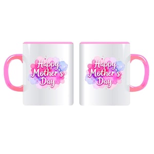 May include: Two white ceramic mugs with pink handles and rims. Each mug features the text "Happy Mother's Day" in a pink and purple watercolor design. The mugs are ideal for gifting.