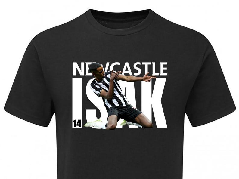 K&ouml;nnte beinhalten: Schwarzes T-Shirt mit einem wei&szlig;en Aufdruck eines Fu&szlig;ballspielers in einem schwarz-wei&szlig;en Trikot mit dem Text "NEWCASTLE ISAK 14" auf der Vorderseite.