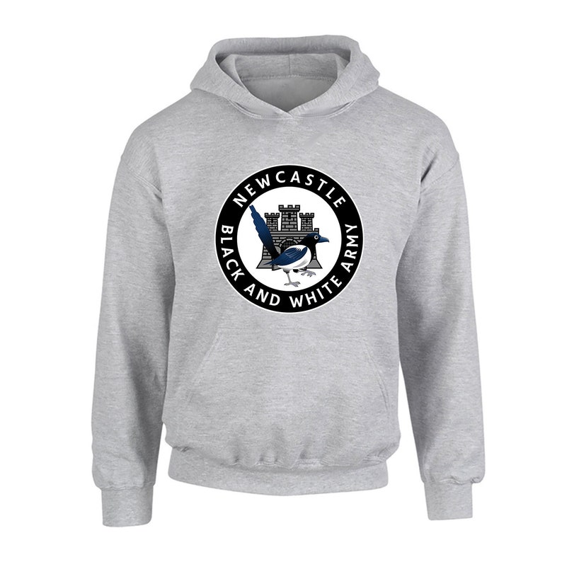 Pu&ograve; includere: Una felpa con cappuccio grigia con un logo circolare bianco e nero che presenta un castello, una gazza e il testo "Newcastle Black and White Army".