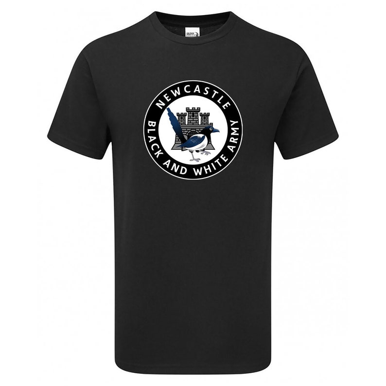 以下が含まれることがあります： 黒地に白の円形のグラフィックがプリントされたTシャツ。グラフィックには、白黒のオオヤマガラ、城、そして「Newcastle Black and White Army」の文字が描かれている。
