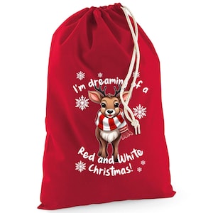 May include: A red Christmas gift bag with a drawstring closure. The bag features a cartoon reindeer wearing a red and white striped scarf, surrounded by snowflakes, and the text "I'm dreaming of a Red and White Christmas!"